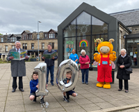 Read all about it! Marking the 10th anniversary of Kilmacolm Library are, from left, Provost Martin Brennan, Archie Hughes, Councillor Stephen McCabe, Sebastian McCracken, Pamela Duncan, Helen Calvert, chair of the Kilmacolm New Community Centre board, Bookbug and Sylvia Megaughin.